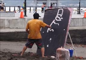 Straßenkünstler malt ein Bild