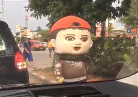 Verstörendes Werbemaskottchen am Autofenster