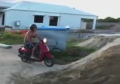 Mit dem Motorroller über einen Erdhaufen springen
