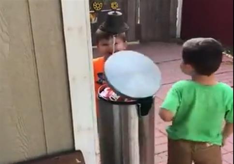 Zwei Kinder und ein Mülleimer