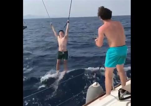 Er lässt sich an Seilen zwischen zwei Segelbooten hochziehen
