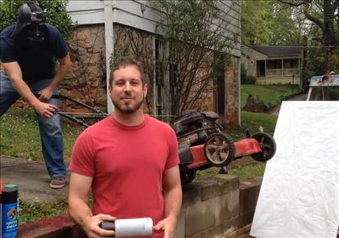 Farbsprühdosen in einen laufenden Rasenmäher werfen