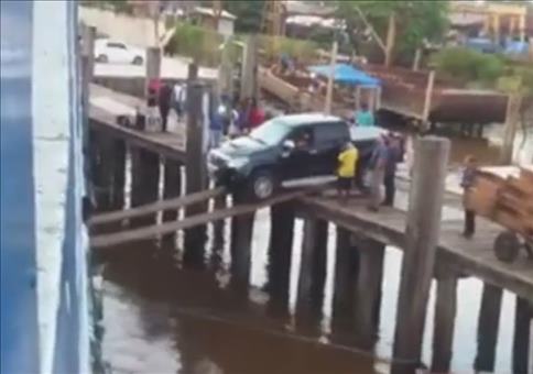 Auto auf losen Planken auf ein Schiff verladen