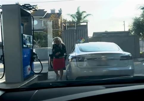 Blondine will an Tankstelle ihren Tesla volltanken