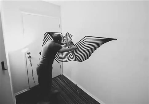 Er klebt Muster mit Klebeband an die Wände