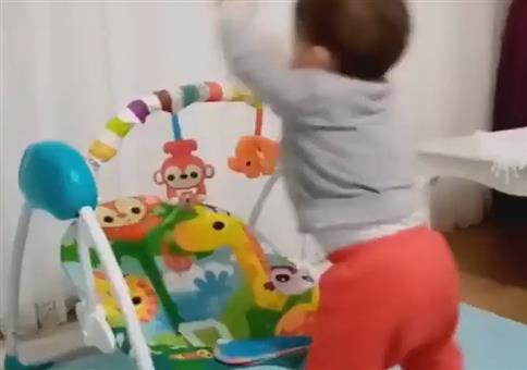 Kleinkinde wirft sich in Babyschaukel