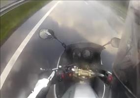 Motorradfahrer fährt durch eine kleine Pfütze auf der Autobahn