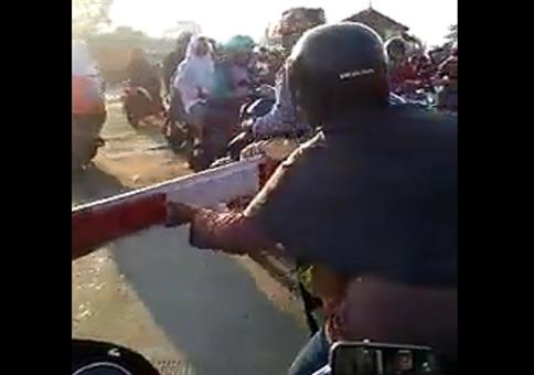 Frau auf Motorroller vs Schranke