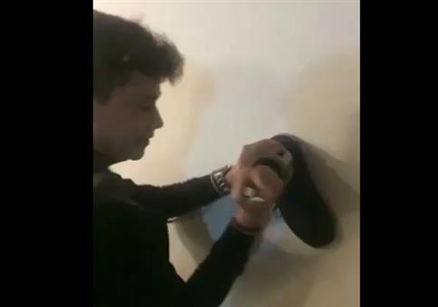 Flasche Wein an der Wand entkorken