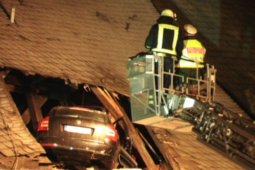 Rettungsdienste bergen in der Nacht zum Montag (26.01.2009) in Limbach-Oberfrohna (Sachsen) einen Pkw, der bei einem spektakulâ°ren Unfall im Dach der Kirche von Limbach-Oberfrohna in Sachsen gelandet ist. Der 23 Jahre alte Fahrer wurde bei dem Unfall schwer verletzt, teilte die Polizei in Chemnitz mit. An einer Abzweigung sei der Fahrer mit stark Â¸berhËhter Geschwindigkeit einfach geradeaus Â¸ber eine leicht ansteigende Wiese weitergefahren, hieï¬ es. Foto: Michael Pape dpa/lsn (zu dpa 0041 vom 26.01.2009) +++(c) dpa - Bildfunk+++