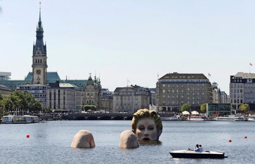 A boat passes a sculpture of a giant mermaid designed by German artist Oliver Voss on the river Alster in Hamburg, northern Germany, Tuesday, Aug. 2, 2011. The sculpture made of styrofoam and steel will be on exhibit for ten days. (AP Photo/dapd, Axel Heimken)