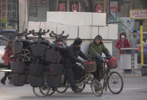 epa03056051 Tricycle delivery men carry loads of office chairs and furniture in Beijing, China, 12 January 2012. Transport restrictions prevent most motorised delivery within Beijing during daylight hours thus preserving the traditional pedal powered service.  EPA/ADRIAN BRADSHAW
